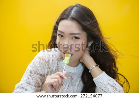 Portrait of Asian Cute young woman eating jelly candies and look camera