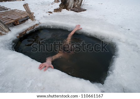 The winter swimming. man in the ice-hole.