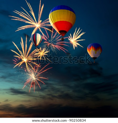 bright colorful fireworks and hot air-balloon of various colors in the night sky at sunset
