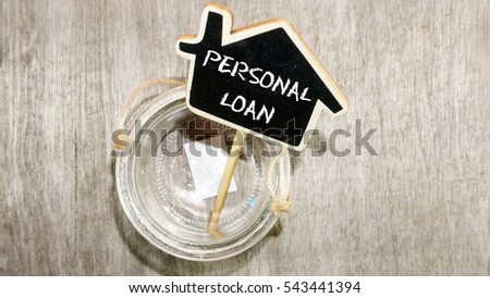 Word Personal Loan on mini chalkboard with empty jar on wooden base