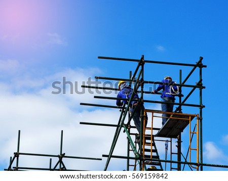 Construction workers working on scaffolding,Man Working on the Working at height with blue sky at construction site