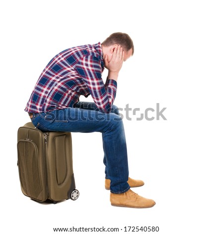 back view man sitting on suitcase. waiting at station. backside view person.  Rear view people collection. Isolated over white background. guy with a travel bag on wheels looking at something at top
