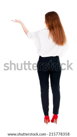 Back view of Beautiful business woman in suite looking at wall and Holds  hand up.  young brunette girl standing. Rear view people. Isolated over white background.