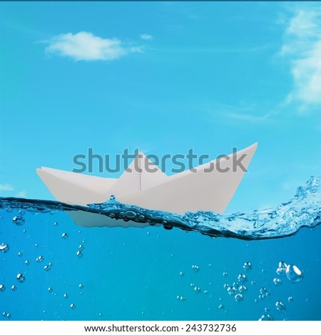 paper boat floating among the waves in the ocean. origami boat floating in the water.