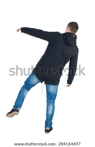 Balancing young man or dodge falling man. Rear view people collection.  backside view of person.  Isolated over white background. A guy in a black jacket with a hood on his right leg wobbles.