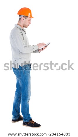 young engineer in a protective helmet with tablet computer in the hands of. Isolated over white background. Standing right side towards the US, engineers are working on the tablet.