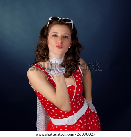 Pretty young girl blowing kiss. Black background.