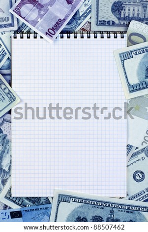Opened spiral notepad (notebook) sheet in a cage on money background ( euro and dollars cash).  stained blue.
