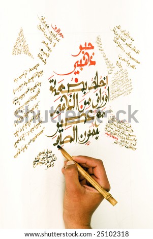 Arabic calligraphy being written by the artist using a hand made pen