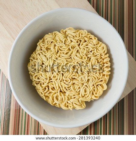 Cuisine and Food, Asian  Dried Instant Noodles Blocks for Cooked or Soaked in Boiling Water in White Bowl.