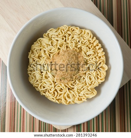 Cuisine and Food, Asian Dried Instant Noodles Blocks with Flavoring Powder for Cooked or Soaked in Boiling Water in White Bowl.