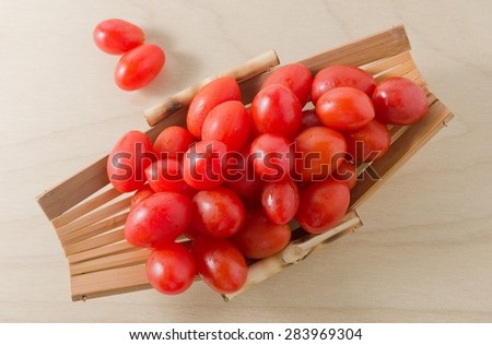 Vegetable, Fresh Ripe Red Grape Tomatoes or Cherry Tomatoes on A Small Wooden Boat.