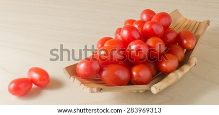 Vegetable, Ripe Red Grape Tomatoes or Cherry Tomatoes on A Small Wooden Boat.