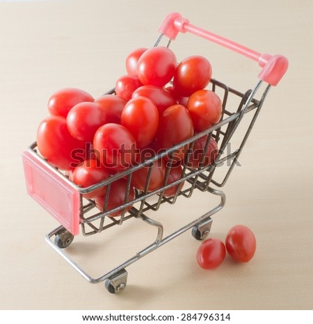 Vegetable, Small Shopping Cart Full with Fresh Ripe Red Grape Tomatoes or Cherry Tomatoes.