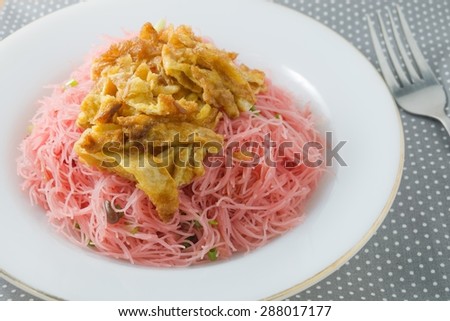 Thai Cuisine and Food, Dish of Red Stir Fried Rice Vermicelli Topping with Julienne Omelet.