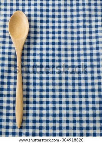Kitchen Wood Utensil Wooden Spoon on A Blue and White Checked Towel Background.