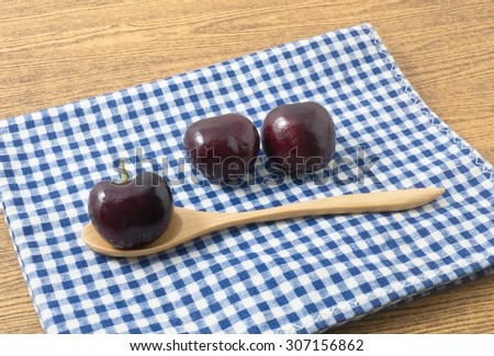 Fresh Fruits, Pile of Ripe and Sweet Red Plums A Very Good Source of Vitamin C on Blue and White Checked Towel.