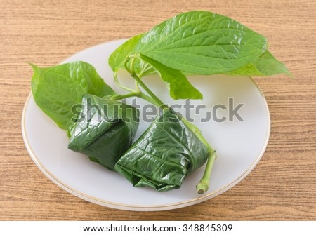 Thai Traditional Snack and Dessert, Dish of Miang Kum or Sweet and Spicy Betel Leaf Wrap Filled with Coconut, Peanuts, Dried Shrimp, Chiles and Lime.