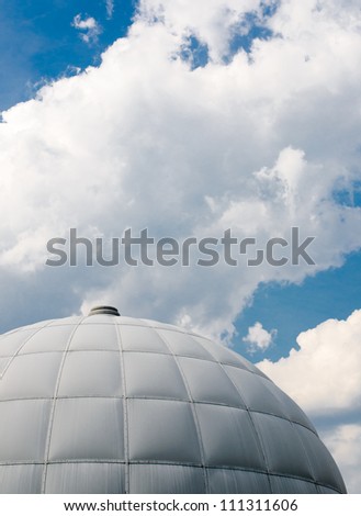 dome of building below blue skies with clouds (offset with room for text)