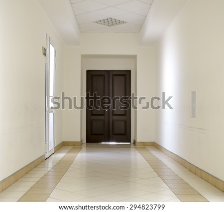 Kiev, Ukraine - July 6, 2015: White hallway with marble floor and brown door in hospital