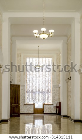 Kiev, Ukraine - July 6, 2015: White hallway with marble floor, brown doors and window in hospital