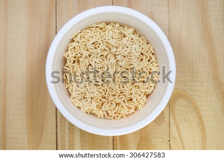 instant noodles in plastic bowl on wood background
