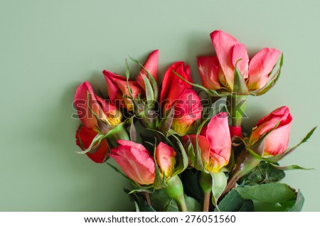 Seven wilted roses on a green background