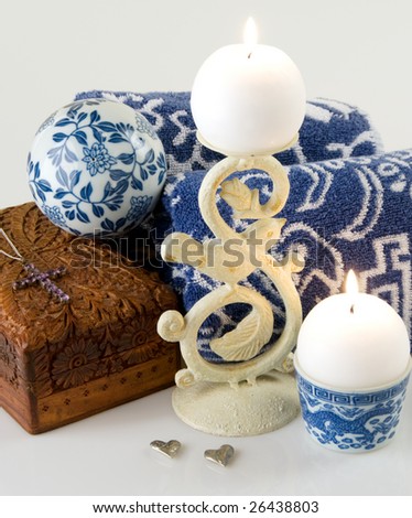 Candles with towels, a carved box, beaten metal hearts, candle holders, and an amethyst cross