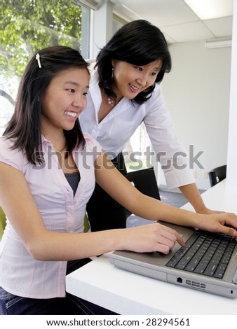 Young student learning computer skills with the help of her teacher