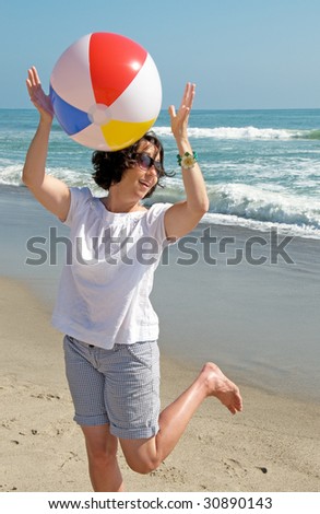 Woman at the ocean playing with a beach ball