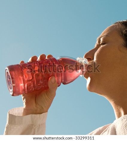 Girl drinking sport drink in the heat of the sun