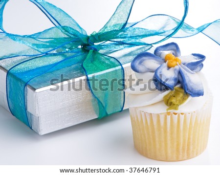 Mini cupcake and silver gift box with blue ribbon