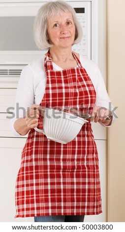 Grandma cooking in her kitchen wearing a red plaid apron