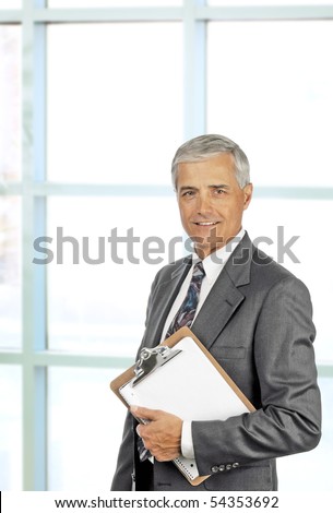 Smiling senior executive holding clipboard