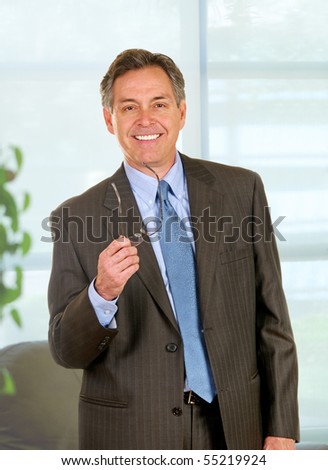 Middle age businessman in executive office wearing suit and tie