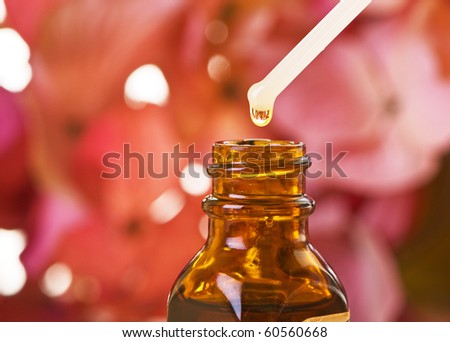 Flower essence in amber bottle with blossoms. Shallow depth of field