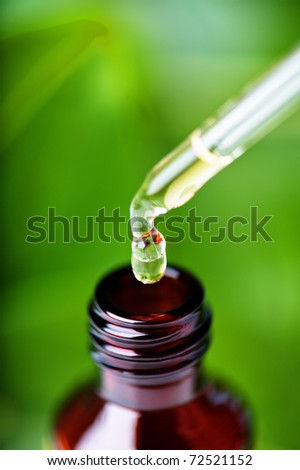 Amber bottle with glass dropper containing liquid that could be herbal essence, scented oil, homeopathic remedy, beauty treatment, aromatherapy, alternative medicine, science experiment, etc.