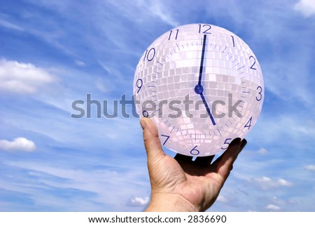 Man holding crystal orb with clock, against a cloudy, blue sky.