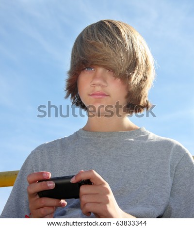 stock photo Cute teen boy with cell phone texting