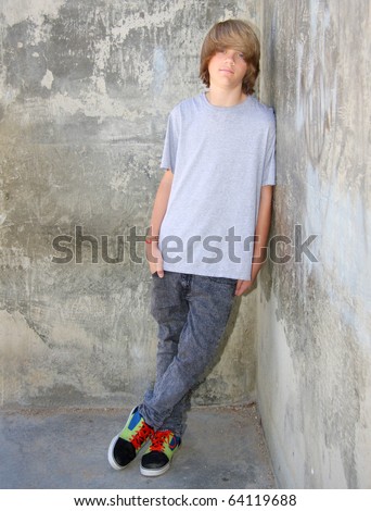 stock photo Cute teen boy leaning against a cement wall