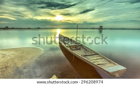 Sunset boat with the bow towards the sun is radiating rays \
horizon pave the dive location. Smooth water surface gives very peaceful setting in the countryside Hue