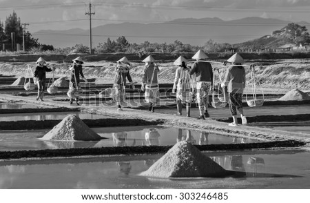 In Khanh Hoa, Vietnam, June 30th, 2015: Group salt farmers is salt in the salt pans bear on a summer afternoon Hon Khoi salt uh, Khanh Hoa, Vietnam