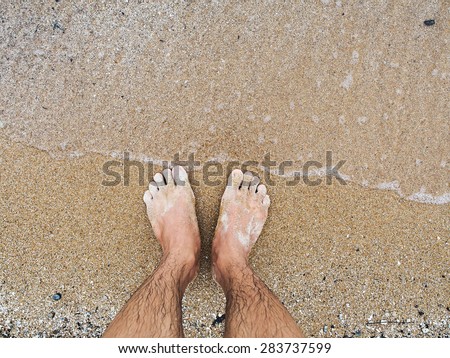 Man 's feet on the beach.