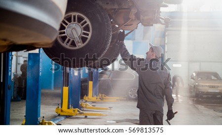 Garage automobile service - a mechanic checks the transmission