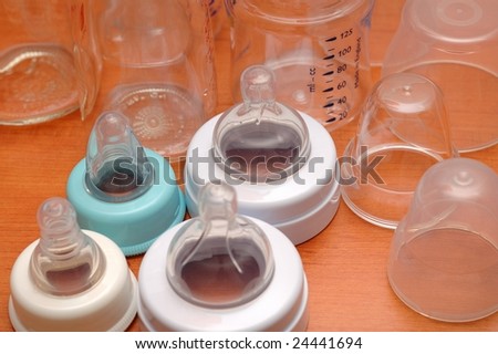 Baby feeding bottles with cover and scale, isolated.
