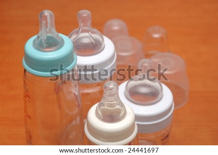 Baby feeding bottles with cover and scale, isolated.