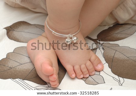 Cute baby feet with silver chain.