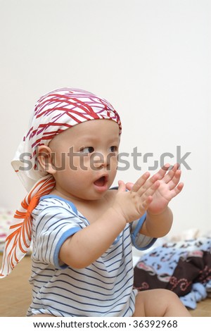 it is a cute chinese baby, he is clapping his hands. he is 8 months old.