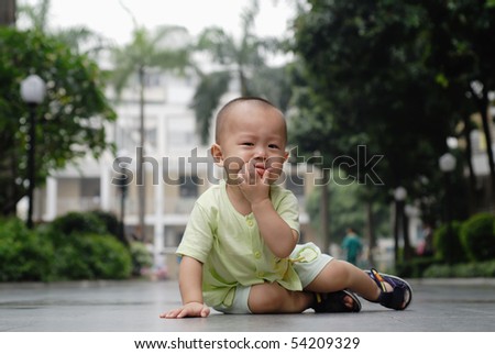 it is a cute chinese baby, he is crying in the outdoor.