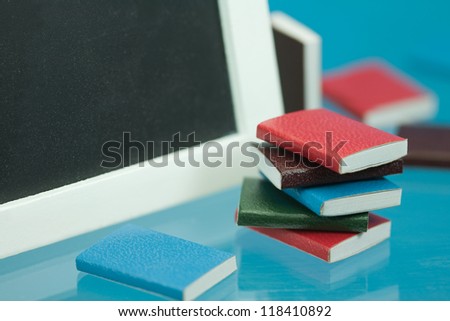back to school concept with miniature school books and blackboard